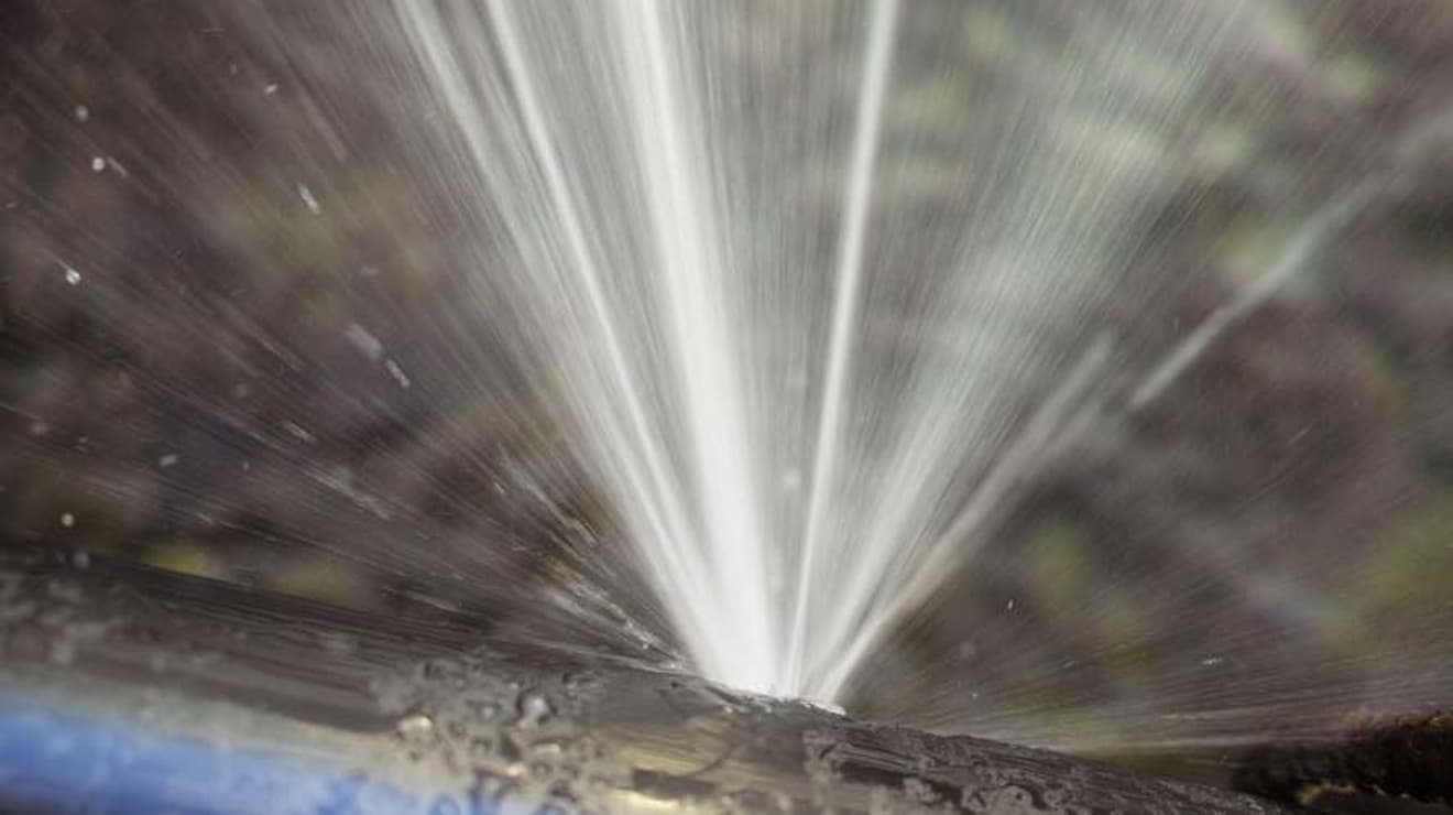 burst water main pipe spraying out water