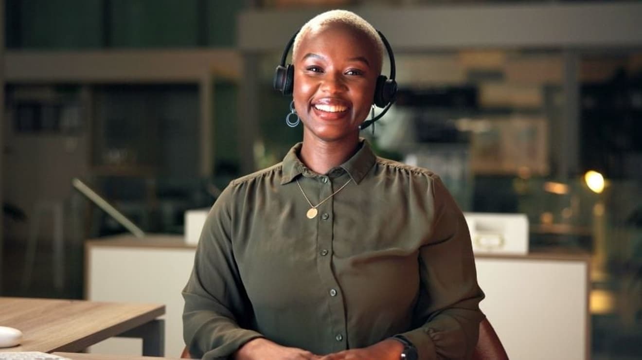 Smiling black customer services woman in call centre