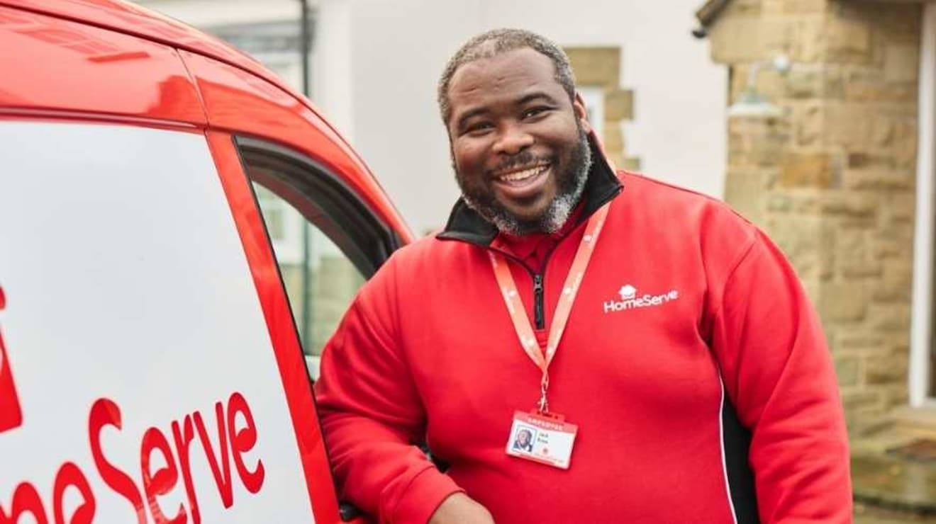 Smiling HomeServe engineer standing by his van