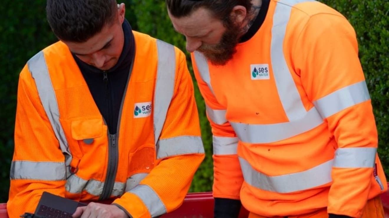 SES engineers looking at a laptop on site