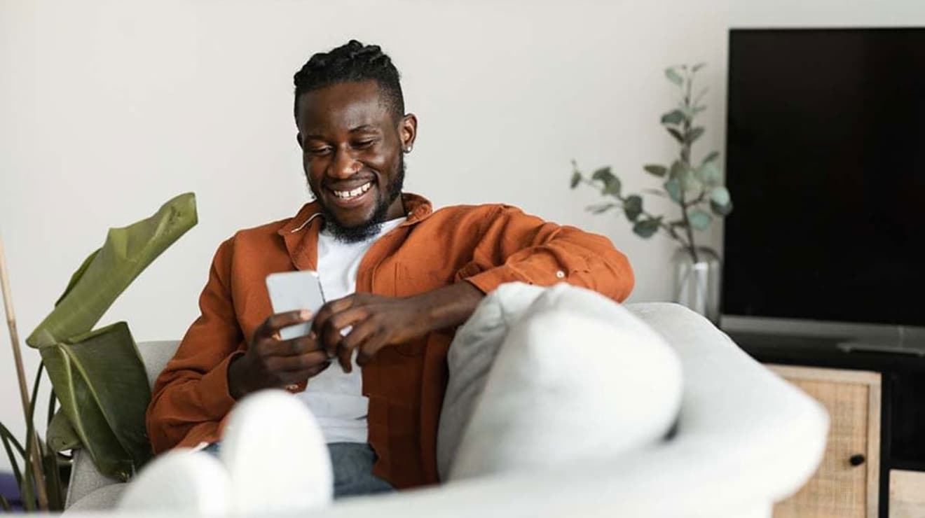 Man using mobile payment on sofa