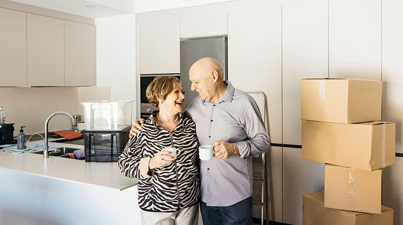 Couple moving home with cups of tea in hand