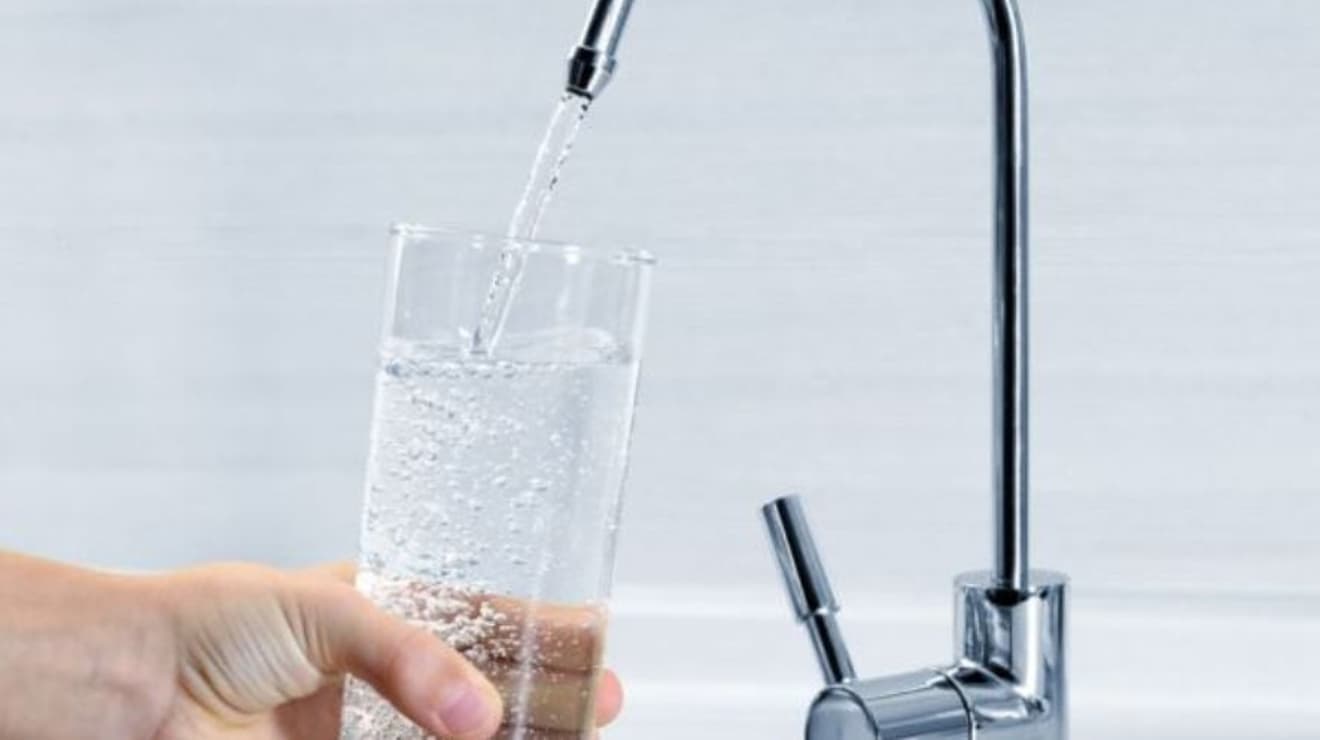 Kitchen tap filling a glass of water