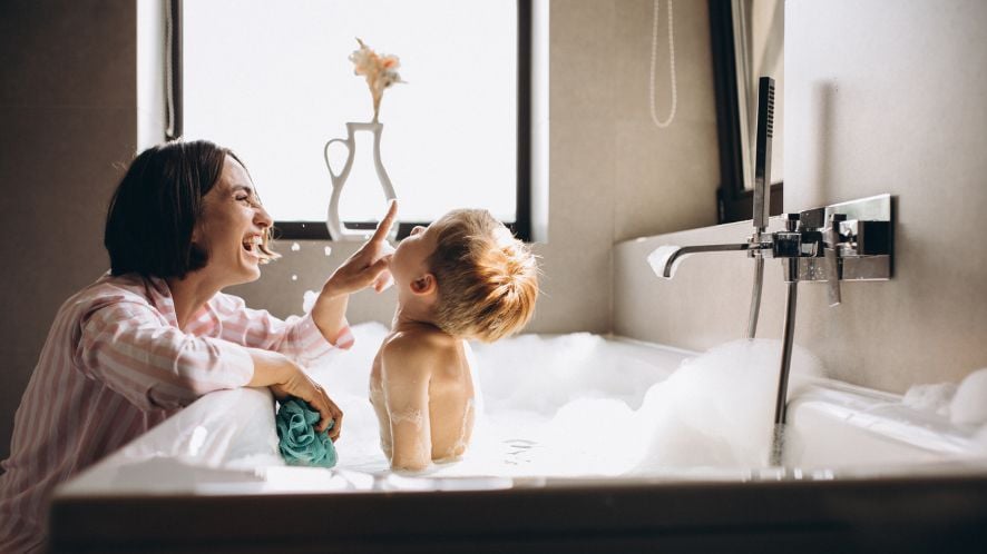 Mum bathing her son in a bubble bath