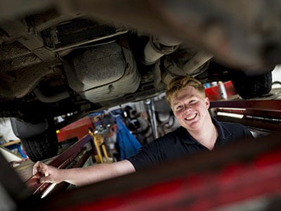 Man servicing a car with a smile
