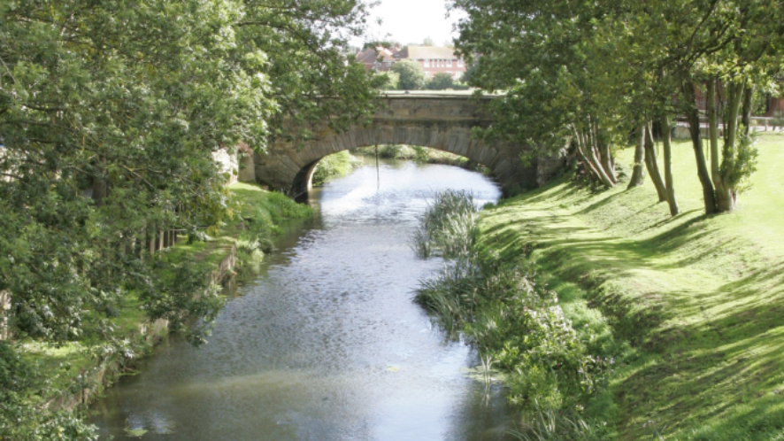 Bridge over a river with green river banks