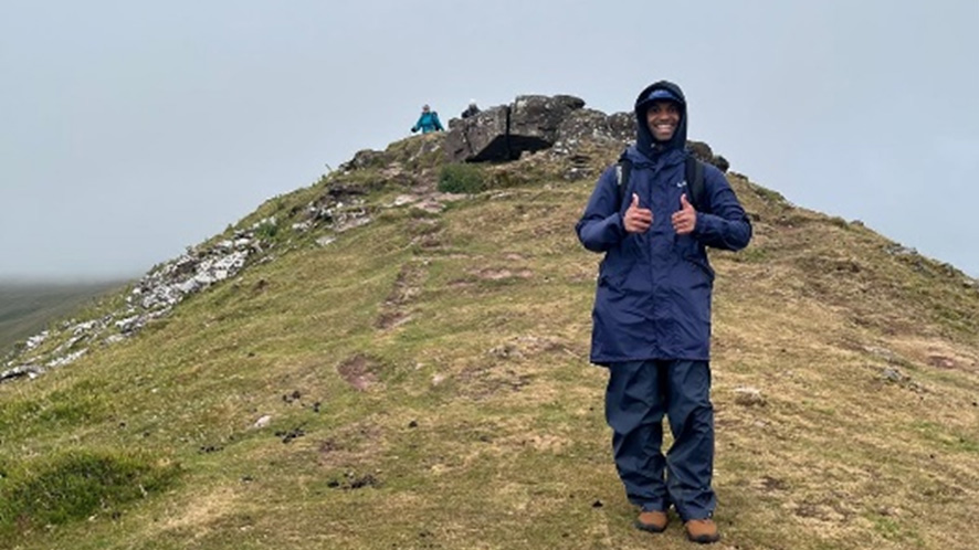 Raghav Mandana, a Pennon Energy Graduate climbing hill in Brecon Beacons in wet weather